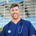 smiling-male-healthcare-worker-outside-hospital-resized